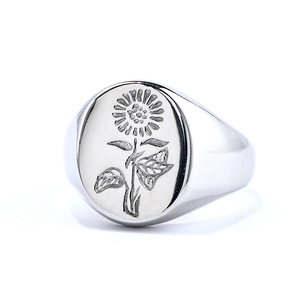Silver stainless steel oval ring with sunflower relief design on a white background