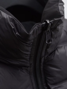 Detailed close-up of high-quality zipper and stand collar on black quilted vest