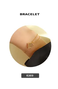 Detailed close-up of 18k gold heart charm bracelet with delicate beaded chain design