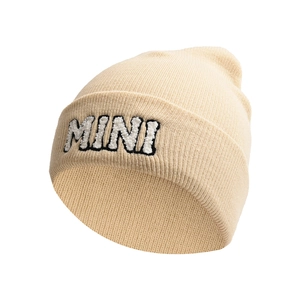 Close-up of beige knit beanie with MINI letter embroidery and thick ribbed texture