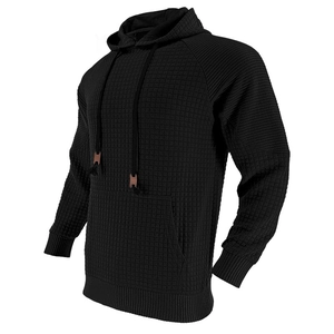 Detail der schwarzen Waffelstrick-Textur am Herren-Hoodie mit vorderer Kängurutasche