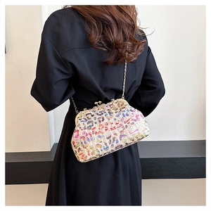 Detail of colorful leopard straw evening bag with gold chain and vintage metal clasp closure