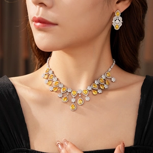Model wearing luxury silver necklace and earring set with yellow teardrop gemstones
