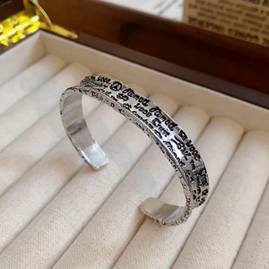 Macro shot of vintage silver open cuff bracelet with hammered texture and engraved words