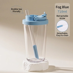 Detail view of 710ml clear Tritan tumbler with blue lid and retractable straw design