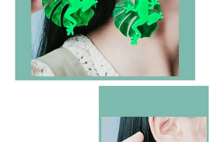 Close-up of model wearing green frog and leaf acrylic earrings for Halloween style