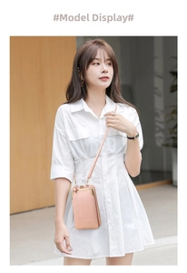 Pale pink vertical quilted leather phone bag with gold metal clasp on a white dress model