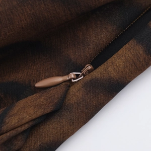 Gros plan sur la texture du tissu imprimé léopard marron foncé avec détail de fermeture éclair