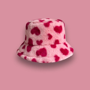 Pink plush bucket hat with red heart patterns on a soft faux fur winter basin hat
