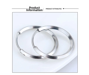 Macro shot of silver geometric hoop earrings with polished finish on white background