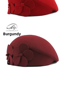 Detail of burgundy wool beret featuring elegant 3D floral decoration on a solid surface