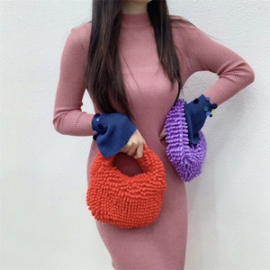Detailed texture of fluffy chenille plush handbag in vibrant red and purple candy colors