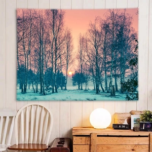 Detail of a sunset forest landscape tapestry hanging in a cozy bedroom with warm lights