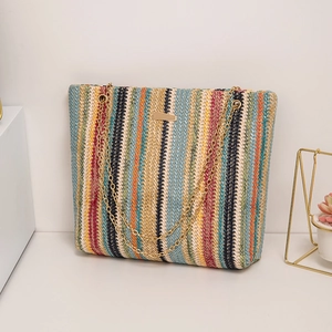 Summer rainbow striped woven tote bag with a golden chain strap on a modern white surface
