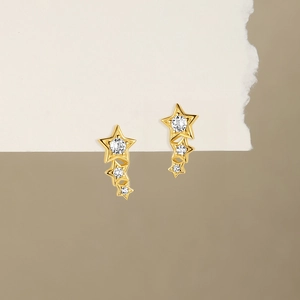 Detailed view of golden star-shaped tassel earrings with inlaid clear sparkling crystals