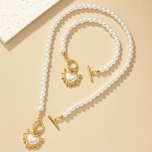 Detail of baroque pearl necklace and bracelet set with golden heart charms and OT clasp