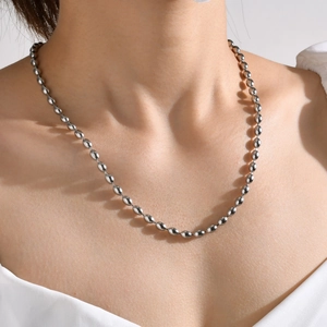 Close-up of silver-tone stainless steel rice bead chain necklace worn by a model