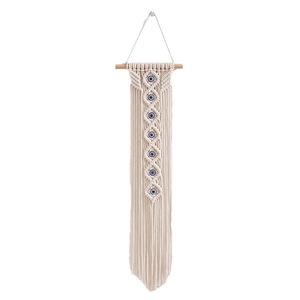 Detailed close-up of handmade woven cotton tapestry with blue evil eye beads and wood rod