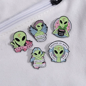 Set of 5 cute cartoon alien enamel pins with motivational quotes on canvas bag