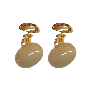 Élégantes boucles d'oreilles ovales plaquées or avec goutte en résine beige sur fond blanc