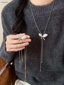 Detail of elegant butterfly pendant necklace with baroque pearls and long tassels