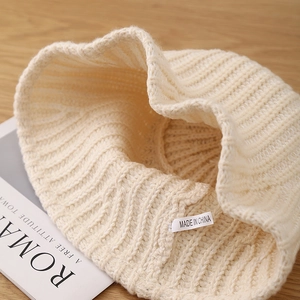 Cozy cream white ribbed knit bucket hat for women on a rustic wooden background