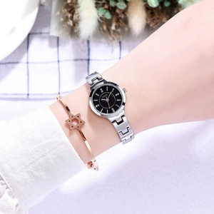 Detail of silver steel watch with black diamond dial worn on female model wrist