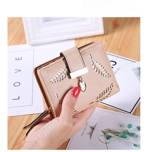 Detailed view of apricot wallet with leaf hollow pattern and metal pendant decoration