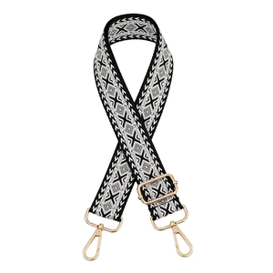 Detail of adjustable ethnic style bag strap with black and white embroidery and gold clips