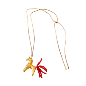 Golden pony pendant necklace with red tassel and beige wax cord on white background