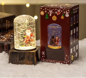 Detail of Santa Claus snow globe lamp with warm LED lights and vintage wood base