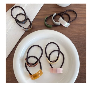 Detail of colorful acetate hair ties with geometric marble patterns and gold label detail