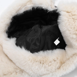 Detail view of winter trapper hat showing black quilted lining and soft faux fur trim