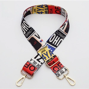Detail of adjustable wide shoulder strap with colorful graffiti pattern and gold metal hooks