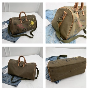 Detail of army green travel duffel bag with colorful doodle prints and leather trim