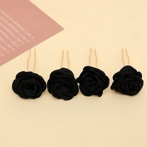 Detail of four black fabric rose hair pins with gold U-shaped metal clips for bridal hair
