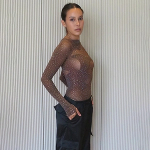 Détail d'un body en maille marron transparent avec strass brillants et manches longues