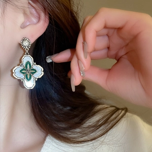 Gros plan de boucles d'oreilles fleurs vintage avec dorure et détails en émail