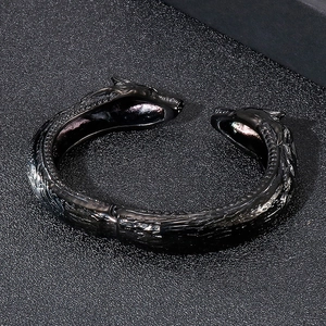 Vue détaillée des écailles et têtes de dragon sur un bracelet en acier noir articulé