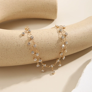 Detail of gold-plated nose ring chain with shimmering rhinestones on a ceramic stand