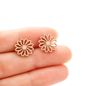 Detail of rose gold hollow lotus stud earrings held to show small size and polished finish