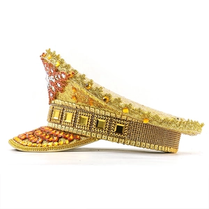 Macro detail of gold sequins and amber rhinestones on a decorative captain hat