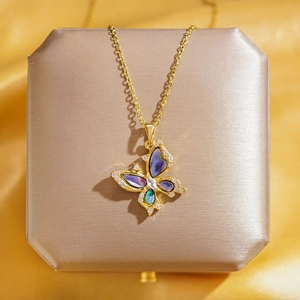 Collier papillon doré raffiné avec ailes en nacre colorée sur fond de satin de luxe