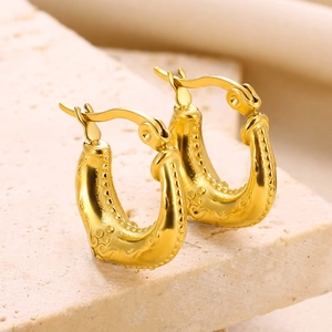 Macro shot of 18K gold plated stainless steel U-shaped earrings with embossed pattern