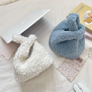 Sherpa fleece knot wrist bags in cream and blue colors shown with lifestyle props