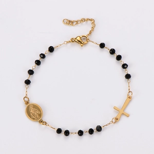 Détail d'un bracelet religieux avec perles noires et médaille de la Vierge Marie dorée