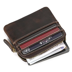 Detail of dark brown leather coin purse with vintage texture and visible white stitching