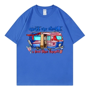 Blue oversized T-shirt with US flag camper graphic and patriotic slogan in flat lay