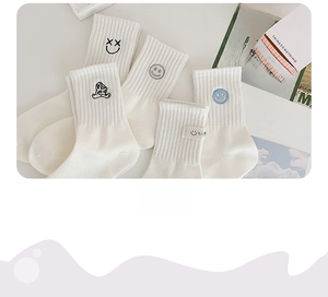 Nahaufnahme weißer Baumwollsocken mit verschiedenen Emoji-Stickereien und Hello-Etiketten