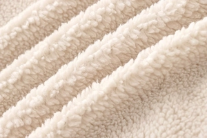 Close-up detail of soft beige teddy fleece fabric with thick texture and cozy feel